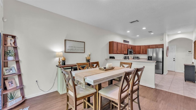 6365 Torrington Cir, Lakeland, FL 33811 - dining area with arched walkways, light wood-style flooring, and recessed lighting