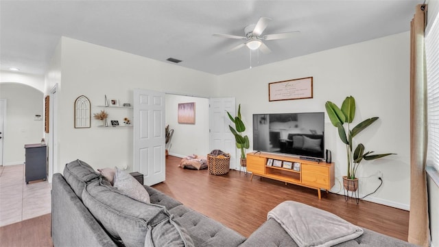 6365 Torrington Cir, Lakeland, FL 33811 - living area featuring arched walkways, a ceiling fan, and wood finished floors
