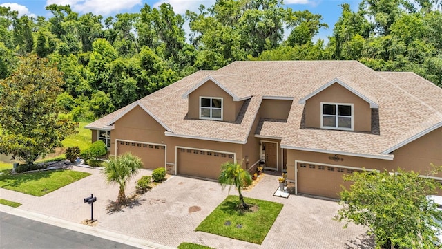 6365 Torrington Cir, Lakeland, FL 33811 - view of front of house featuring stucco siding, decorative driveway, a garage, and a shingled roof