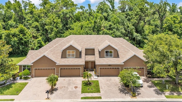 6365 Torrington Cir, Lakeland, FL 33811 - view of front facade featuring driveway, an attached garage, a shingled roof, and stucco siding