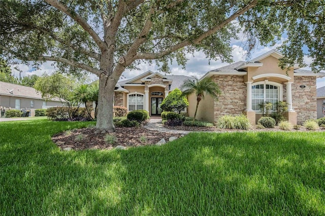 2026 Indian Sky Cir, Lakeland, FL 33813 - view of front facade with stucco siding, a front lawn, and stone siding