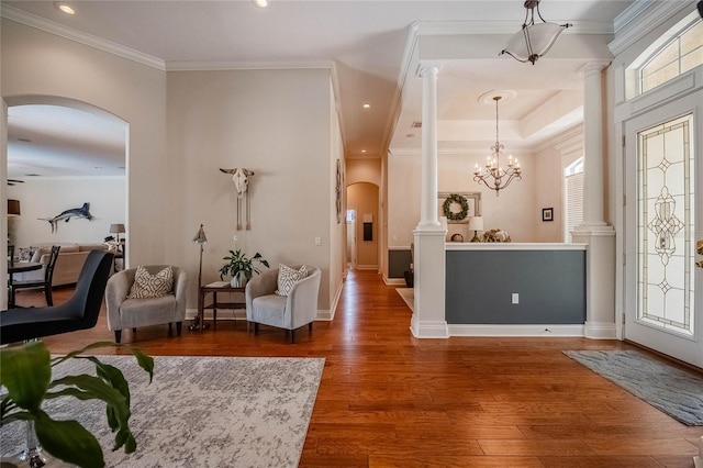 2026 Indian Sky Cir, Lakeland, FL 33813 - entrance foyer with arched walkways, ornate columns, wood finished floors, ornamental molding, and a chandelier