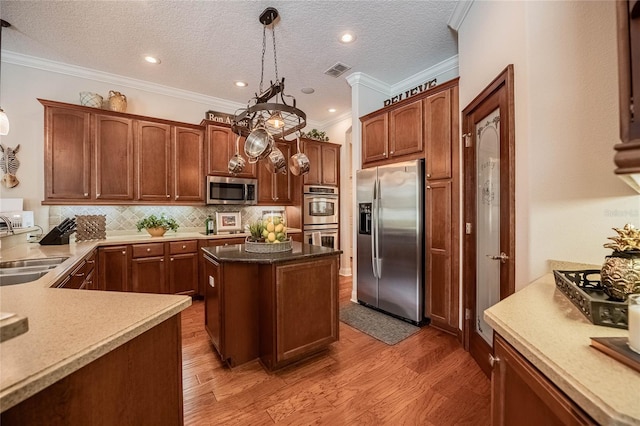 2026 Indian Sky Cir, Lakeland, FL 33813 - kitchen featuring stainless steel appliances, ornamental molding, decorative backsplash, light wood-type flooring, and decorative light fixtures