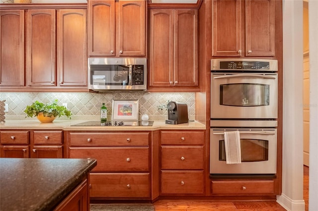 2026 Indian Sky Cir, Lakeland, FL 33813 - kitchen featuring stainless steel appliances, tasteful backsplash, light wood finished floors, and brown cabinets