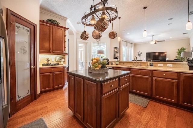 2026 Indian Sky Cir, Lakeland, FL 33813 - kitchen with crown molding, ceiling fan, a textured ceiling, light wood finished floors, and open floor plan