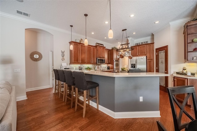 2026 Indian Sky Cir, Lakeland, FL 33813 - kitchen featuring appliances with stainless steel finishes, a peninsula, a kitchen bar, light countertops, and wood finished floors