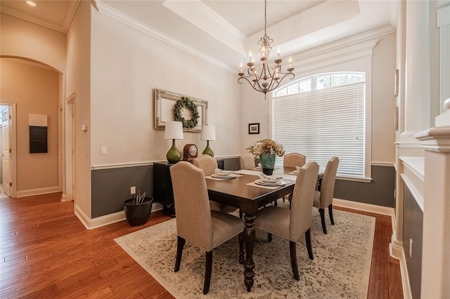 2026 Indian Sky Cir, Lakeland, FL 33813 - dining space featuring arched walkways, a chandelier, plenty of natural light, wood finished floors, and crown molding