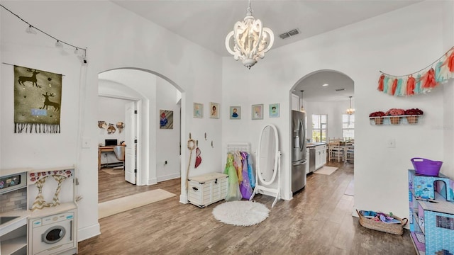 1028 15th St NE, Winter Haven, FL 33881 - entryway featuring arched walkways, a chandelier, and wood finished floors