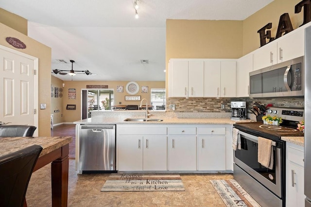 1420 Meadows Pond Dr, Bartow, FL 33830 - kitchen featuring appliances with stainless steel finishes, a ceiling fan, white cabinetry, a peninsula, and backsplash