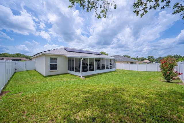 1420 Meadows Pond Dr, Bartow, FL 33830 - rear view of house with a sunroom, solar panels, a fenced backyard, stucco siding, and a gate