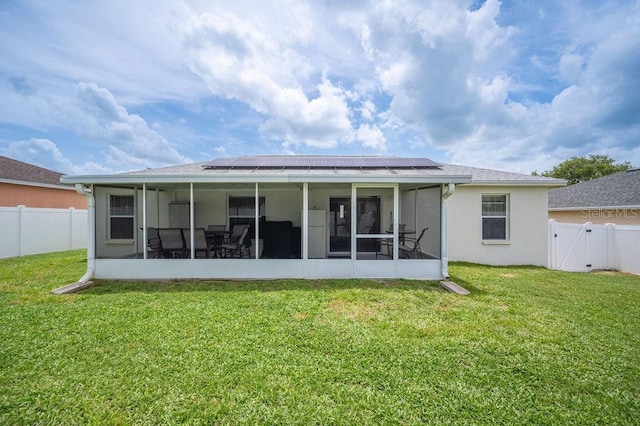 1420 Meadows Pond Dr, Bartow, FL 33830 - back of property with a sunroom, roof mounted solar panels, a gate, and a fenced backyard