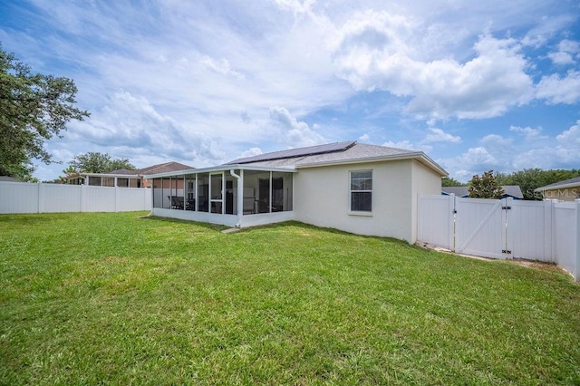 1420 Meadows Pond Dr, Bartow, FL 33830 - rear view of house featuring a gate, a sunroom, roof mounted solar panels, and a fenced backyard
