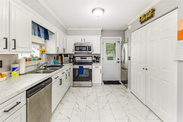 2443 Delrose Dr E, Lakeland, FL 33805 - kitchen with stainless steel appliances, light marble finish floors, plenty of natural light, white cabinetry, and ornamental molding
