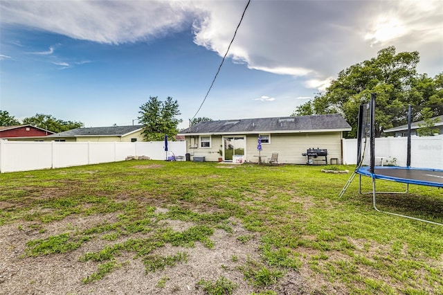 2443 Delrose Dr E, Lakeland, FL 33805 - back of house with a fenced backyard and a trampoline