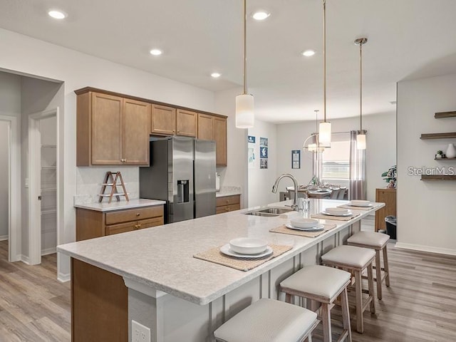 7515 SW 107th Ln, Ocala, FL 34476 - kitchen featuring stainless steel fridge, light countertops, light wood-style flooring, brown cabinets, and recessed lighting