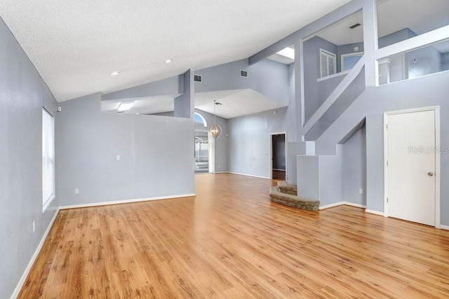 8818 Tottenham Way, Kissimmee, FL 34747 - unfurnished living room with wood finished floors, high vaulted ceiling, and stairs