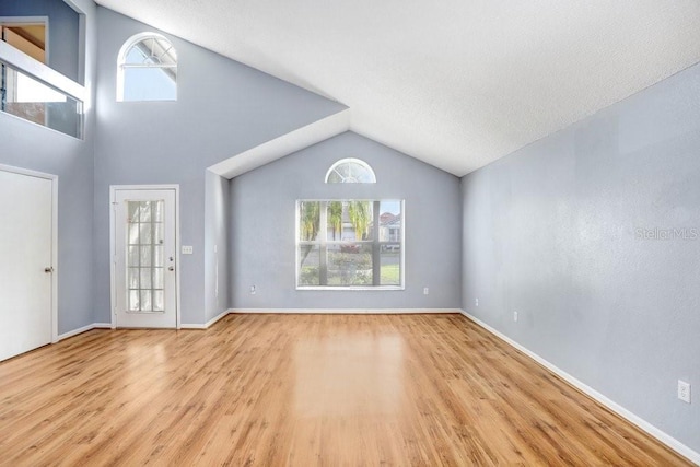 8818 Tottenham Way, Kissimmee, FL 34747 - unfurnished living room with wood finished floors and vaulted ceiling