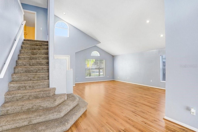 8818 Tottenham Way, Kissimmee, FL 34747 - unfurnished living room with vaulted ceiling, stairs, wood finished floors, and recessed lighting