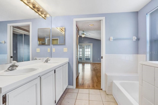 8818 Tottenham Way, Kissimmee, FL 34747 - bathroom with a bath, double vanity, ceiling fan, and tile patterned floors