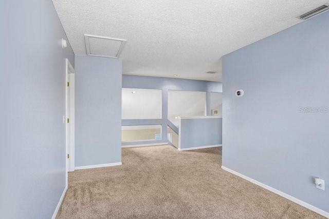 8818 Tottenham Way, Kissimmee, FL 34747 - carpeted spare room featuring a textured ceiling and attic access