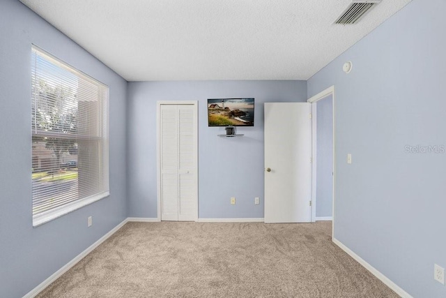 8818 Tottenham Way, Kissimmee, FL 34747 - unfurnished bedroom with carpet flooring, a closet, and a textured ceiling