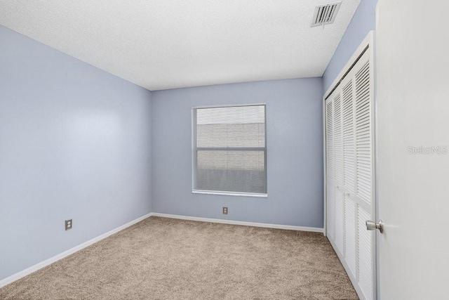 8818 Tottenham Way, Kissimmee, FL 34747 - unfurnished bedroom with carpet floors, a closet, and a textured ceiling
