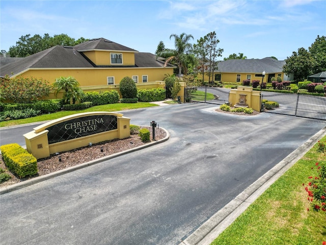 961 Christina Chase Dr, Lakeland, FL 33813 - community sign with a gate, curved driveway, and a residential view