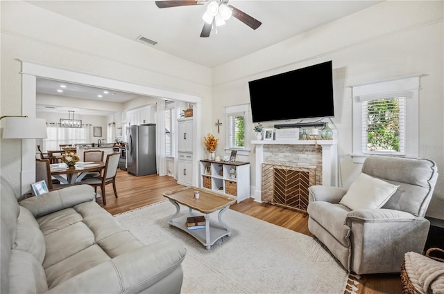 213 Cannon St, Lakeland, FL 33803 - living room with a ceiling fan, light wood-style floors, and a fireplace