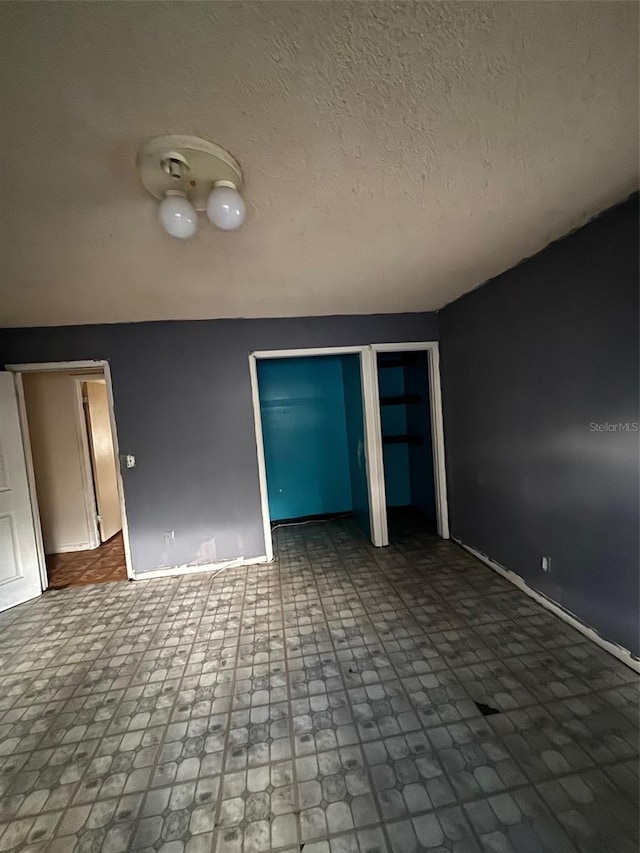 2921 Galaxy Ln, Lakeland, FL 33801 - unfurnished bedroom featuring baseboards and two closets