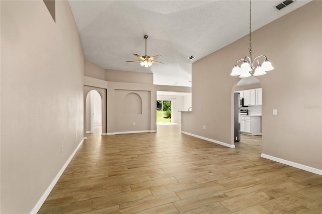 1125 Blackjack Ridge St, Minneola, FL 34715 - unfurnished living room with arched walkways, ceiling fan, light wood-style flooring, and a towering ceiling