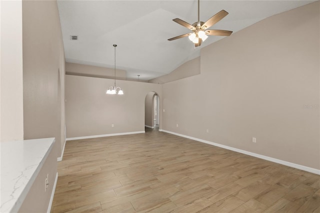 1125 Blackjack Ridge St, Minneola, FL 34715 - spare room featuring ceiling fan, lofted ceiling, arched walkways, light wood finished floors, and a chandelier