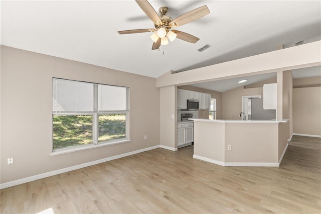 1125 Blackjack Ridge St, Minneola, FL 34715 - unfurnished living room with vaulted ceiling, healthy amount of natural light, ceiling fan, and light wood-style flooring