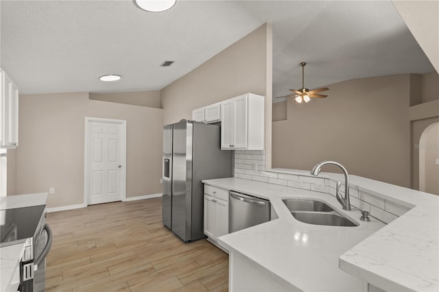 1125 Blackjack Ridge St, Minneola, FL 34715 - kitchen featuring vaulted ceiling, appliances with stainless steel finishes, ceiling fan, white cabinetry, and backsplash