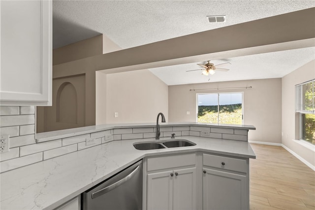 1125 Blackjack Ridge St, Minneola, FL 34715 - kitchen featuring dishwasher, a peninsula, a ceiling fan, light wood-type flooring, and a textured ceiling