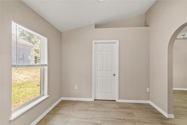1125 Blackjack Ridge St, Minneola, FL 34715 - spare room featuring arched walkways, vaulted ceiling, and light wood-style floors