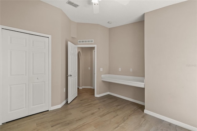 1125 Blackjack Ridge St, Minneola, FL 34715 - unfurnished bedroom with light wood-style flooring, a closet, a ceiling fan, and arched walkways