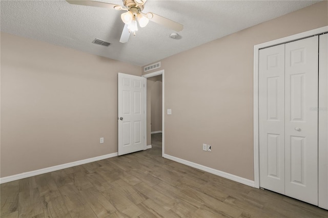 1125 Blackjack Ridge St, Minneola, FL 34715 - unfurnished bedroom with wood finished floors, a closet, a textured ceiling, and ceiling fan