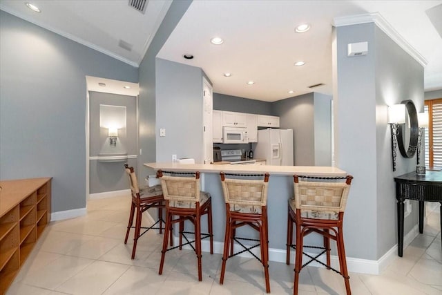 3608 54th Dr W Unit 202, Bradenton, FL 34210 - kitchen with white appliances, white cabinetry, a kitchen bar, a peninsula, and ornamental molding