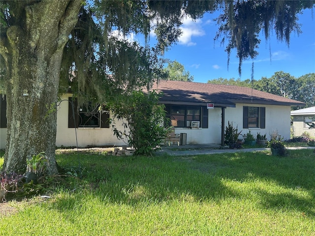 2250 Maple Hill Dr, Lakeland, FL 33811 - view of front of house with a front yard, stucco siding, and cooling unit