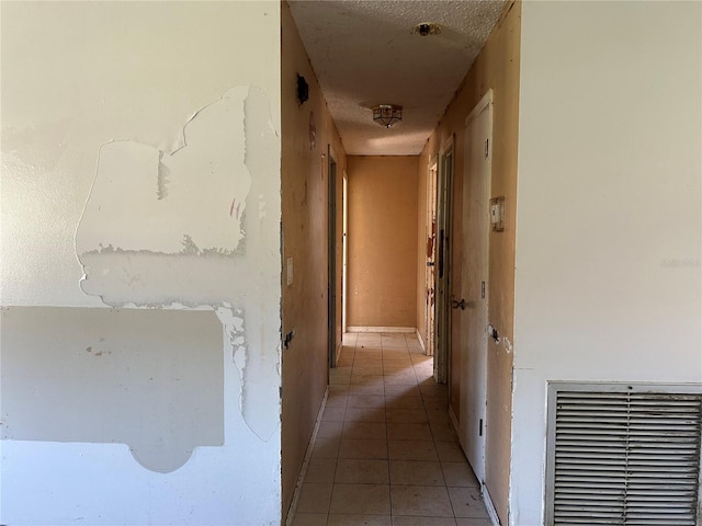 2250 Maple Hill Dr, Lakeland, FL 33811 - hallway with light tile patterned floors and a textured ceiling