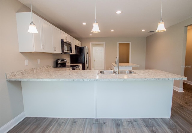 4042 Old Bartow Eagle Lake Rd, Bartow, FL 33830 - kitchen with appliances with stainless steel finishes, wood finished floors, a peninsula, light countertops, and white cabinetry