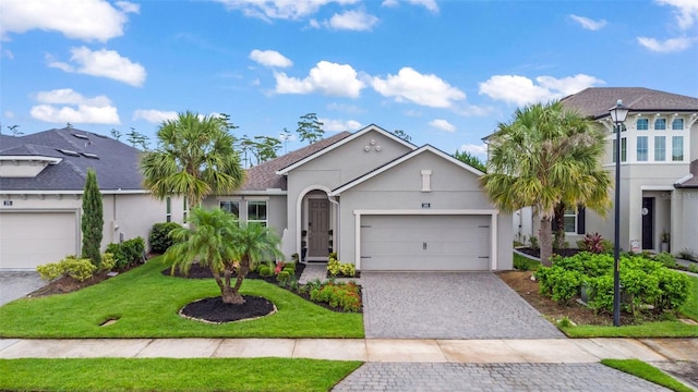 180 Azure Mist Way, Daytona Beach, FL 32124 - view of front facade with stucco siding, a garage, decorative driveway, and a front lawn