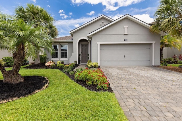 180 Azure Mist Way, Daytona Beach, FL 32124 - view of front of property featuring stucco siding, decorative driveway, an attached garage, and a front yard
