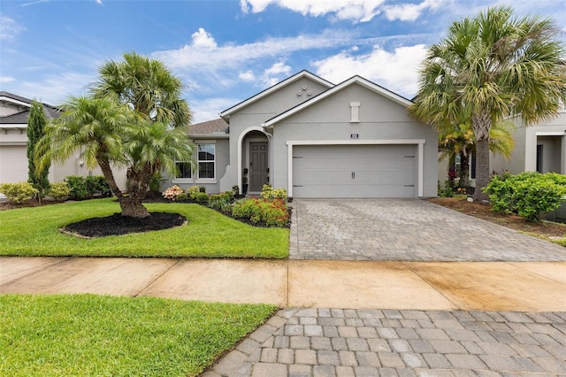 180 Azure Mist Way, Daytona Beach, FL 32124 - ranch-style home featuring stucco siding, a front lawn, decorative driveway, and a garage