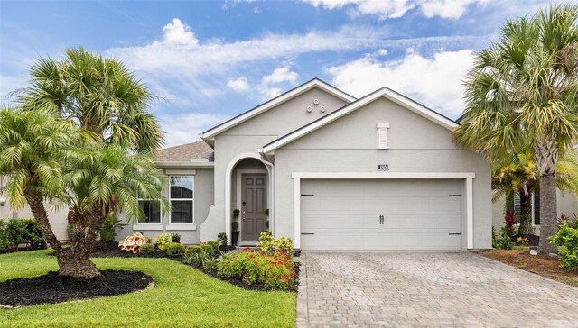 180 Azure Mist Way, Daytona Beach, FL 32124 - view of front of property with stucco siding, an attached garage, decorative driveway, and a front yard