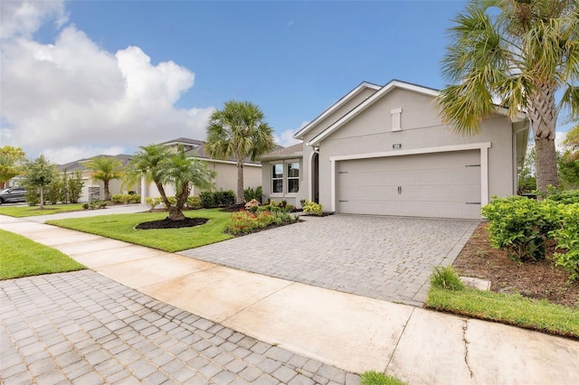 180 Azure Mist Way, Daytona Beach, FL 32124 - view of front of home featuring stucco siding, decorative driveway, a garage, and a front lawn