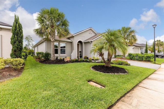 180 Azure Mist Way, Daytona Beach, FL 32124 - view of front of home featuring driveway, a front yard, and stucco siding