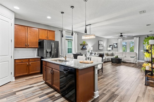180 Azure Mist Way, Daytona Beach, FL 32124 - kitchen featuring black dishwasher, brown cabinetry, light wood finished floors, a textured ceiling, and recessed lighting