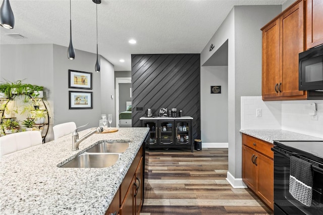 180 Azure Mist Way, Daytona Beach, FL 32124 - kitchen with black appliances, dark wood-style floors, a textured ceiling, light stone countertops, and pendant lighting