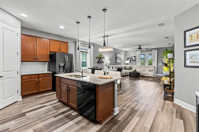 180 Azure Mist Way, Daytona Beach, FL 32124 - kitchen with black appliances, brown cabinets, a textured ceiling, decorative light fixtures, and light wood-style floors